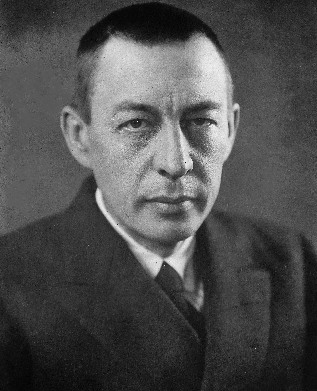 Black-and-white portrait of Sergei Rachmaninoff, facing the camera in a suit and tie.